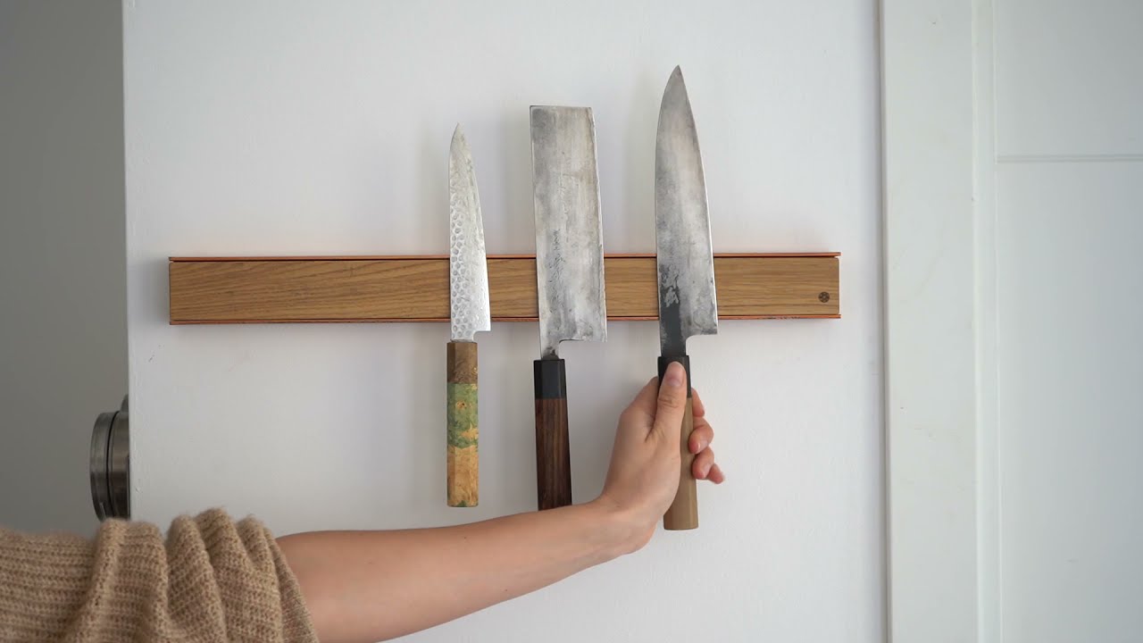 Woman mounting Japanese knives on copper magnetic rack