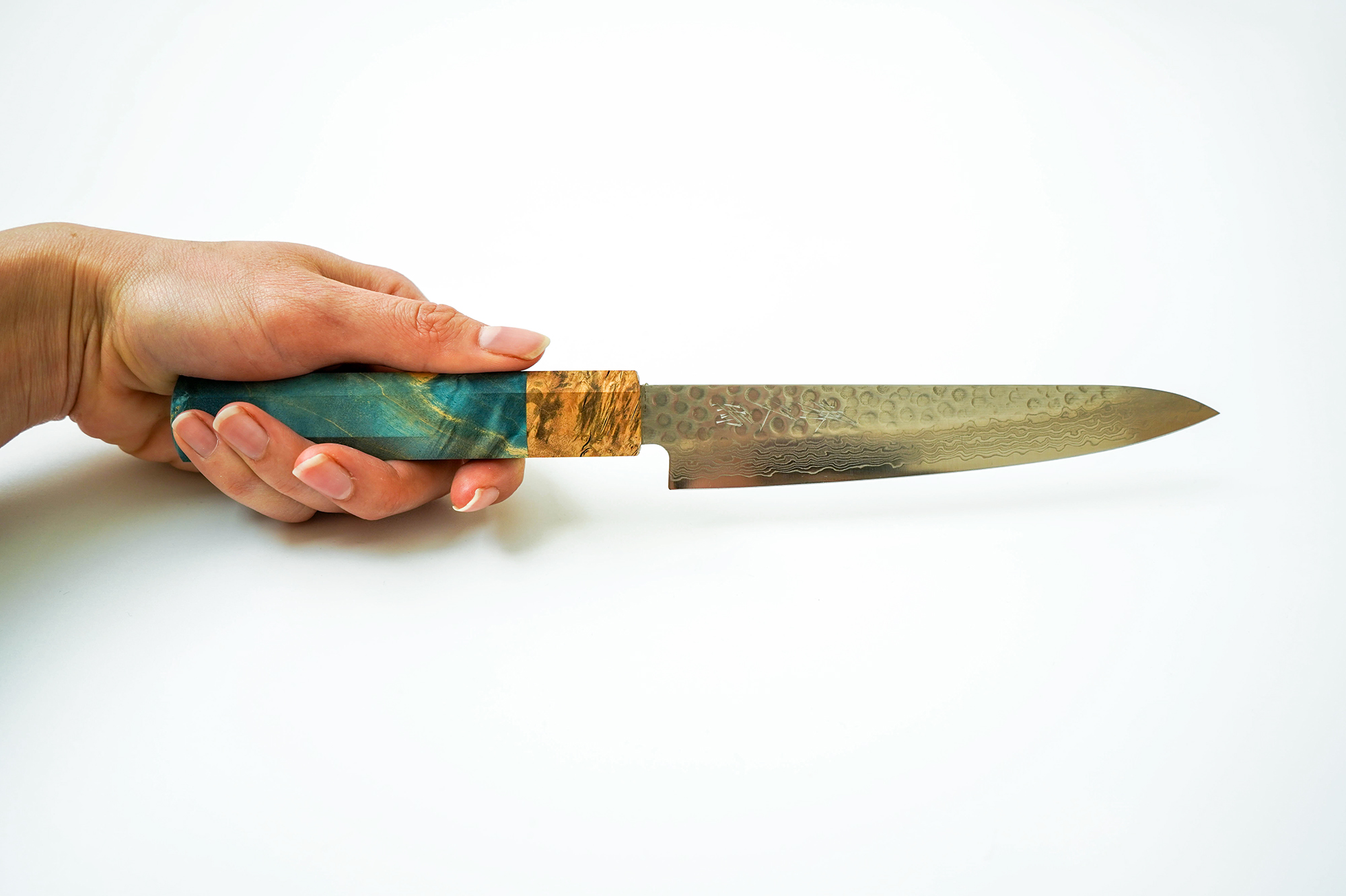 Sakai Kyuba petty blue held in hand white background