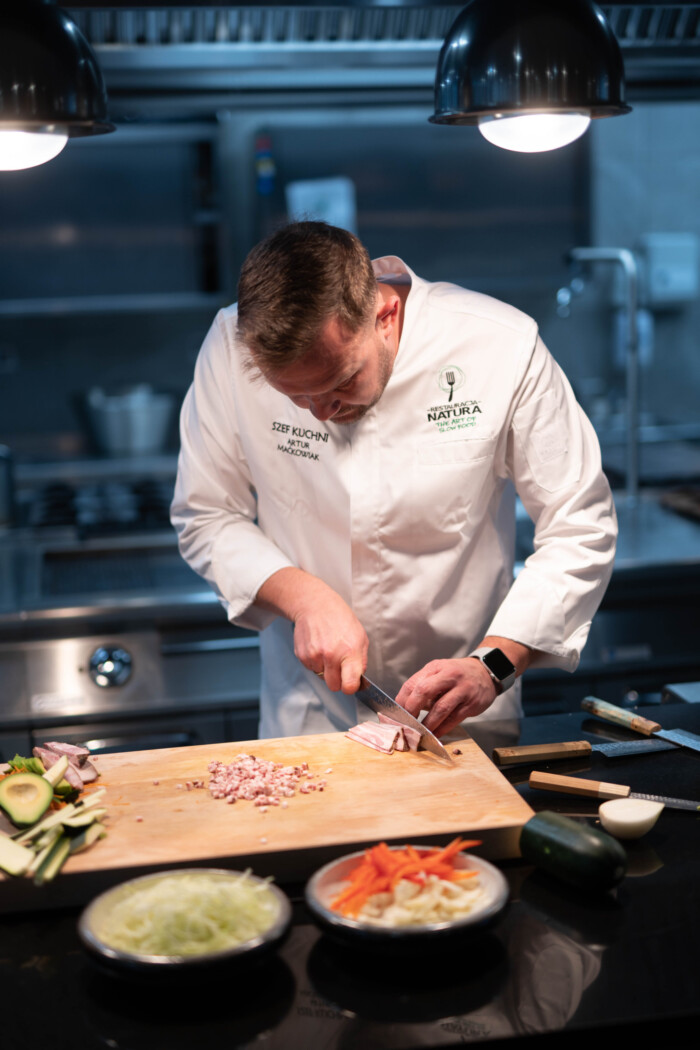 Koch schneidet Speck mit Sakai Kyuba Gyuto - japanische Küchenmesser