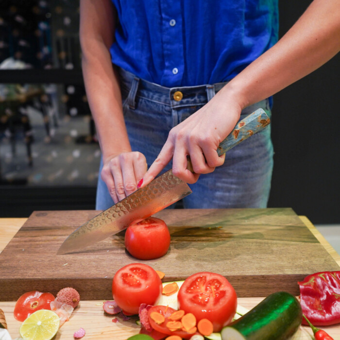 frau schneidet mit sakai kyuba blauem kochmesser