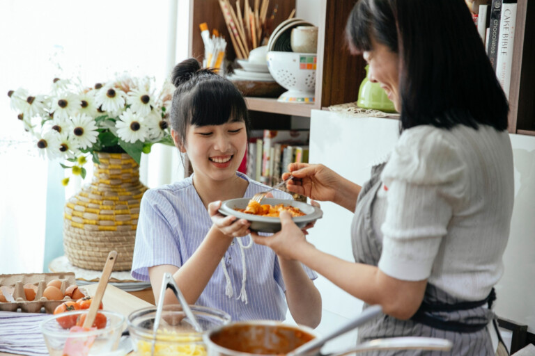 Mother cooking pasta for daughter