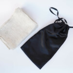 Kitchen Linen Set Of 6 Tea Towels – Natural, next to polyester bag Kitchen Linen Set Of 6 Tea Towels – Natural, next to polyester bag